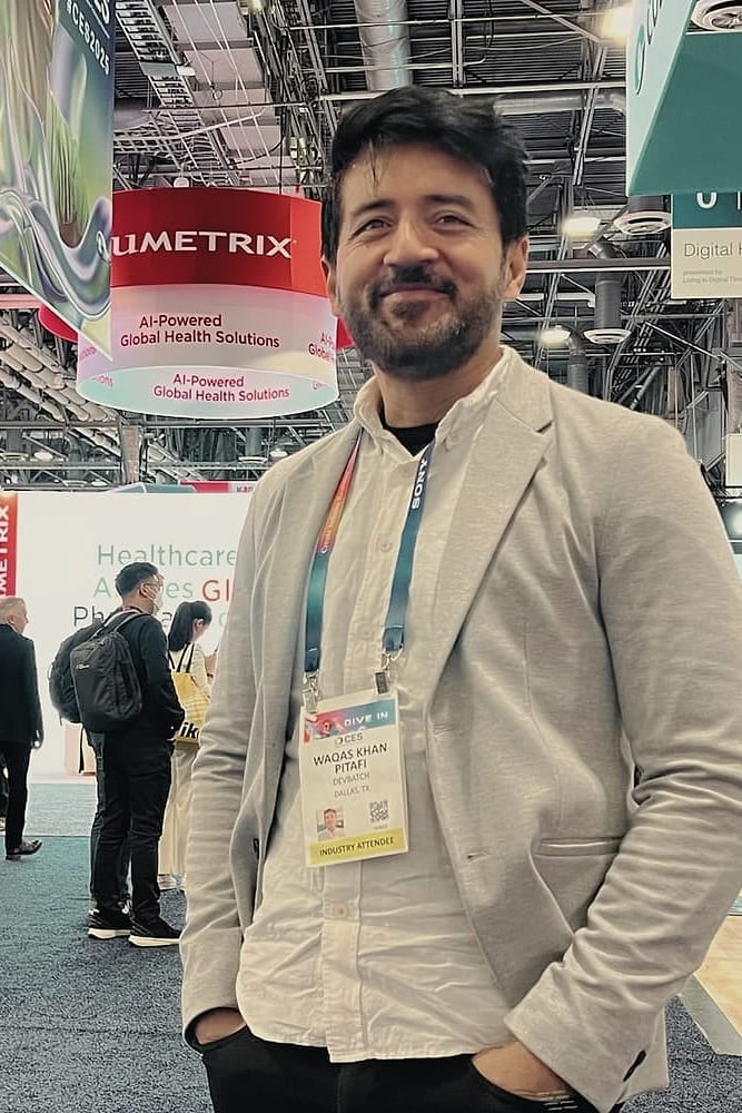 Waqas Khan Pitafi at CES, in a cream blazer with an industry-attendee badge