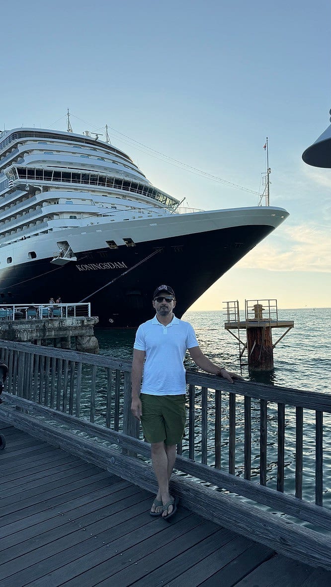 Waqas Khan Pitafi off-duty on a pier, with a cruise ship behind him